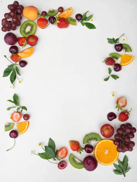 Various fruits frame on white background. Different berries and fruits on white background. Copy space. Top view