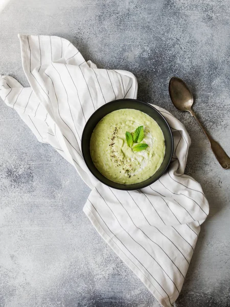 Vegetarian green cream soup of green peas with mint