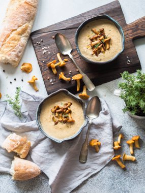 Mavi kase ve baget rustik masa ve ahşap tahta Cantharellus cibarius krem çorbası. Sonbahar gıda kavramı. Üstten görünüm