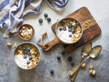 İki granola ve yoğurt, yaban mersini ve badem ile top. Sağlıklı kahvaltı. Üstten görünüm