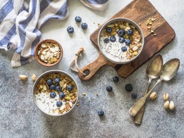 İki granola ve yoğurt, yaban mersini ve badem ile top. Sağlıklı kahvaltı. Üstten görünüm