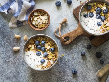 İki granola ve yoğurt, yaban mersini ve badem ile top. Sağlıklı kahvaltı. Üstten görünüm