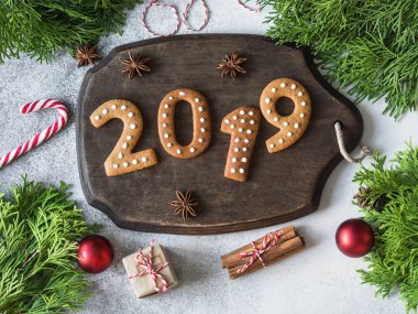 Ginger Noel ve yeni yıl tanımlama numaraları 2019 gri arka plan üzerinde koyu ahşap tahta üzerinde şeklinde. Mevsimlik ambalaj ve yılbaşı öznitelikleri. Üstten görünüm