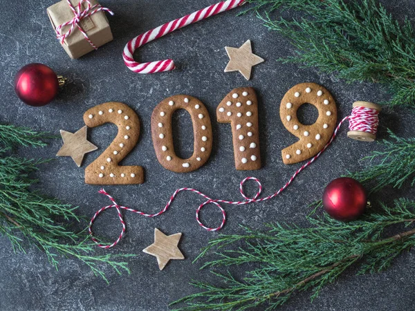 Ginger Noel ve yeni yıl tanımlama numaraları 2019 gri arka plan üzerinde koyu ahşap tahta üzerinde şeklinde. Mevsimlik ambalaj ve yılbaşı öznitelikleri. Üstten görünüm