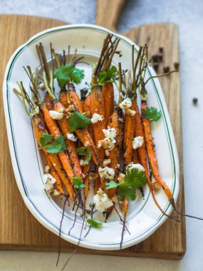 Yumuşak peynir, ceviz ve Salantro beyaz oval plaka üzerinde genç turuncu havuç pişmiş.