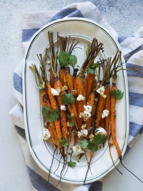 Yumuşak peynir, ceviz ve Salantro beyaz oval plaka üzerinde genç turuncu havuç pişmiş.