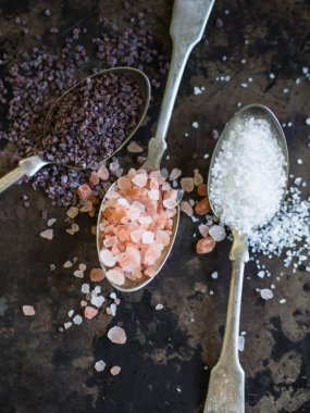 Vintage kaşık koyu arka plan üzerinde çeşitli tuz.