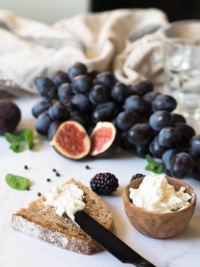 Camembert peyniri, avokado ile tost dilim, prosciutto, roka ve ahşap gemide baharat