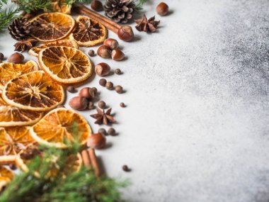 Parlak Noel ve yeni yıl arka plan - Kuru portakal dilimleri ve baharatlar, Ladin ve koniler. Kış mevsimlik içki - mulled yapmak için malzemeler gri arka plan üzerinde şarap