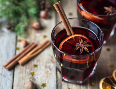 Geleneksel kış alkollü içki - mulled şarap. Meyve ve baharat ahşap masa üzerinde gözlük ile sıcak şarap