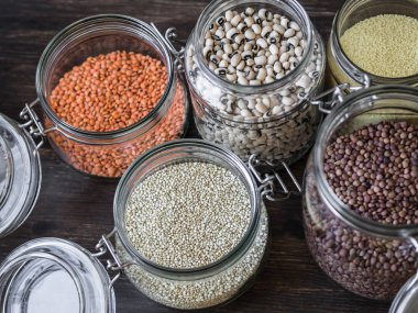 Makarna, mercimek, kuskus, fasulye ve quinoa ile açık cam kavanozlar.