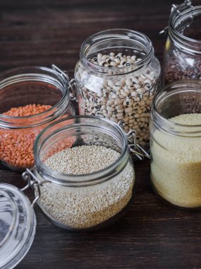 Makarna, mercimek, kuskus, fasulye ve quinoa ile açık cam kavanozlar.
