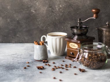Kahve, kahve çekirdekleri, şeker, vintage kahve demliği, kahve değirmeni, cam kavanoz yapmak için çeşitli malzemeler sütçü gri arka plan üzerine tarçın ve anason yıldızlarla ve kahve Kupası.