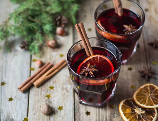 Geleneksel kış alkollü içki - mulled şarap. Meyve ve baharat ahşap masa üzerinde gözlük ile sıcak şarap