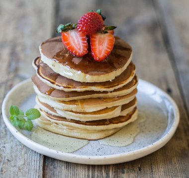 Bal ve çilek beyaz tabakta krep yığını