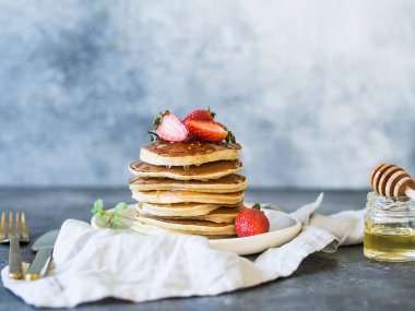 Bal ve çilek beyaz tabakta krep yığını