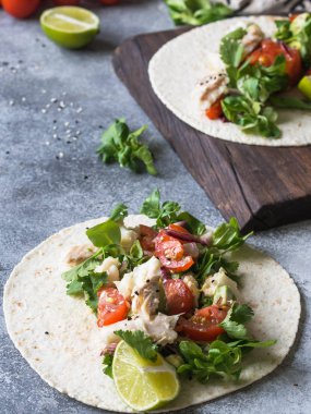 Ekmeği beyaz balık ve sebze ile. Avokado, domates, kırmızı soğan ve cod parça ekmeği gri arka plan üzerine susam ve limon suyu ile serpilir. Meksika yemeği.