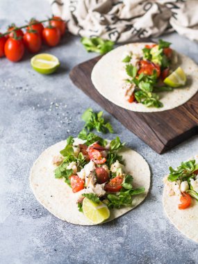 Ekmeği beyaz balık ve sebze ile. Avokado, domates, kırmızı soğan ve cod parça ekmeği gri arka plan üzerine susam ve limon suyu ile serpilir. Meksika yemeği.