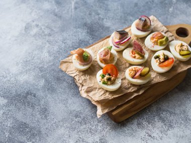 Çeşitli tepesi ile yumurta dolması. Jambon, ringa balığı, salatalık turşusu, sosis, turp, domates, kapari ve susam haşlanmış yumurta yarım üzerinde.