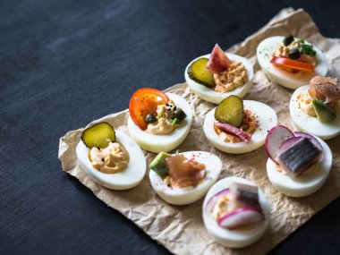 Çeşitli tepesi ile yumurta dolması. Jambon, ringa balığı, salatalık turşusu, sosis, turp, domates, kapari ve susam haşlanmış yumurta yarım üzerinde.