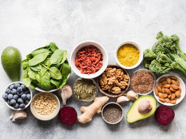 Sağlıklı temiz gıda - sebze, meyve, fındık, superfoods gri bir arka plan üzerinde. Sağlıklı beslenme kavramı.