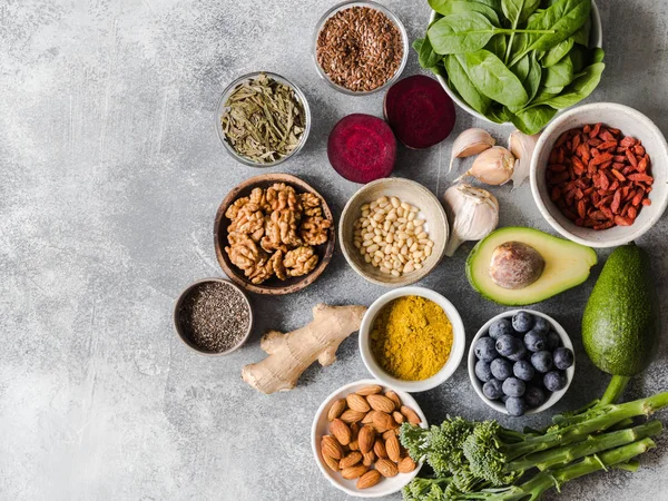 Sağlıklı temiz gıda - sebze, meyve, fındık, superfoods gri bir arka plan üzerinde. Sağlıklı beslenme kavramı.