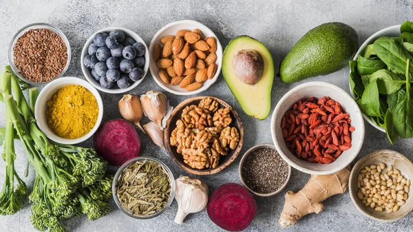 Sağlıklı temiz gıda - sebze, meyve, fındık, superfoods gri bir arka plan üzerinde. Sağlıklı beslenme kavramı.