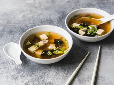 İstiridye mantar ile bir kaşık ve beyaz çubuklar gri bir arka plan üzerinde beyaz bir kase ile Japon miso çorbası. kopya alanı