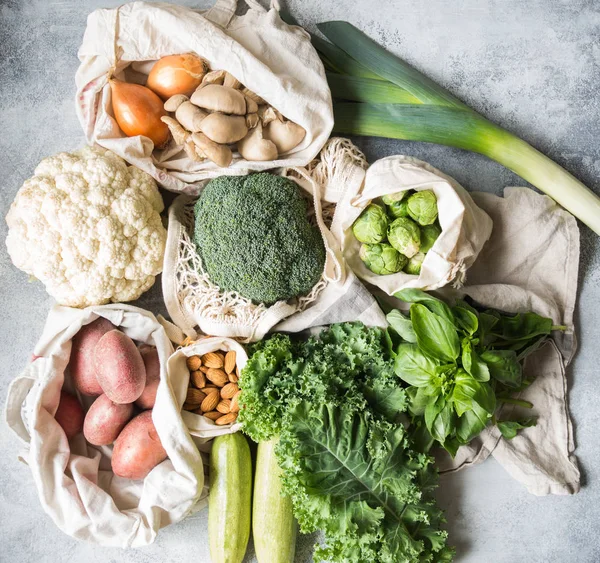 Healthy vegan ingredients for cooking. Various clean wholesome vegetables and herbs in woven bags. Products from the market without plastic. Zero waste concept flat lay. — Stock Photo, Image