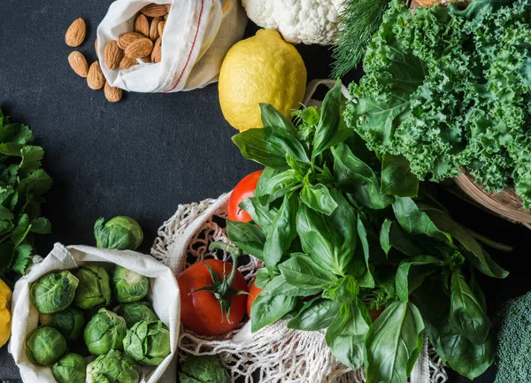 Healthy vegetarian ingredients for cooking. Various clean vegetables, herbs, nut on black background. Products from the market without plastic. Flat lay. Copy space — Stock Photo, Image