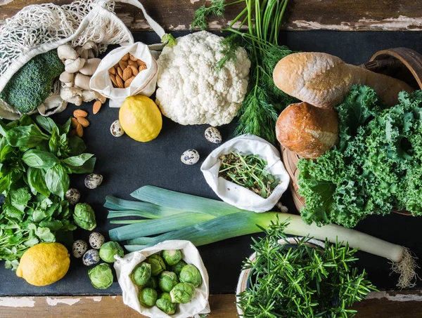 Sağlıklı vejetaryen yemek pişirmek için malzemeler. Çeşitli sebzeler, otlar, fındık ve siyah arka plan üzerine ekmek temiz. Ürün market plastik olmadan. Düz yatıyordu. — Stok fotoğraf