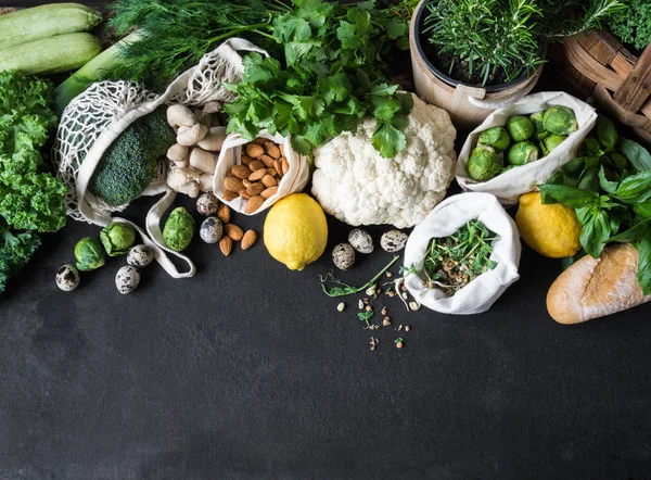 Healthy vegetarian ingredients for cooking. Various clean vegetables, herbs, nut and bread on black background. Products from the market without plastic. Flat lay. Copy space — Stock Photo, Image