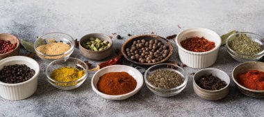 Çeşitli baharatlar gri arka plan üzerinde küçük kase kuru. kopya alanı