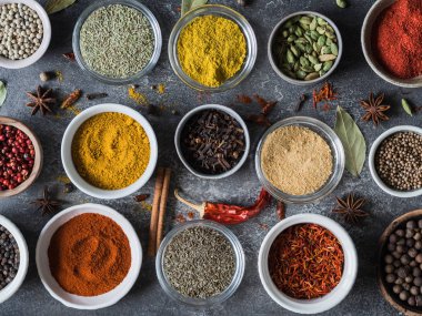 Çeşitli kuru baharat düz gri arka plan üzerinde küçük kase içinde yatıyordu. Üstten Görünüm,