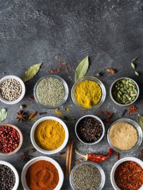 Çeşitli kuru baharat düz gri arka plan üzerinde küçük kase içinde yatıyordu. Üstten Görünüm, kopya alanı