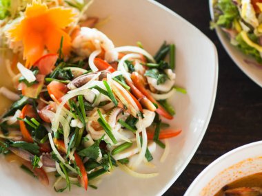 Geleneksel Tay mutfağı. Bir kafede bir tabakta taze sebze ve otlar ve deniz ürünleri ile Salata. Restoranda otantik taze geleneksel Tay yemekleri