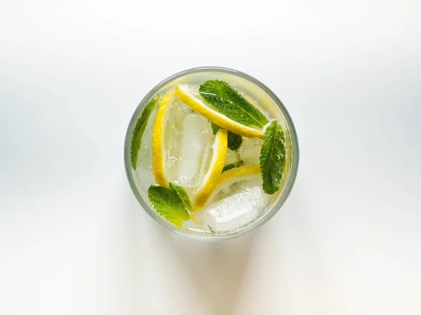 Летний цитрусовый лимонад со льдом в стекле на белом фоне. Вид сверху — стоковое фото