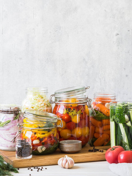 Cooking pickled vegetables. Salting various vegetables in glass jars for long-term storage. Preserves vegetables in glass jars. Variety fermented green vegetables on wood board