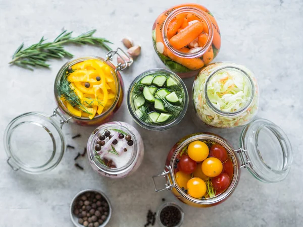 Legumes em conserva. Salgando várias verduras em jarros de vidro do armazenamento a longo prazo. Preserva legumes em frascos de vidro. Variedade vegetais verdes fermentados na mesa . — Fotografia de Stock