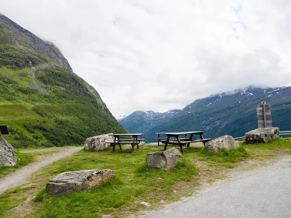 Lugar de picnic: varias mesas familiares de madera con bancos sobre un fondo de montañas en un día nublado — Foto de Stock