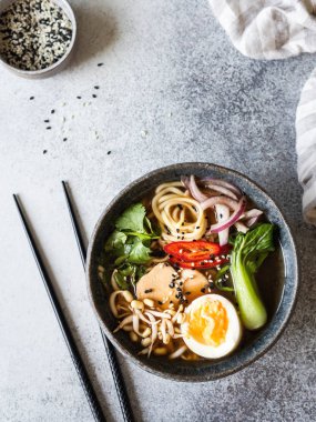 Tavuk, pak choi lahana ve gri arka plan üzerinde yumurta ile Asya Ramen erişte. Üstte görüntü