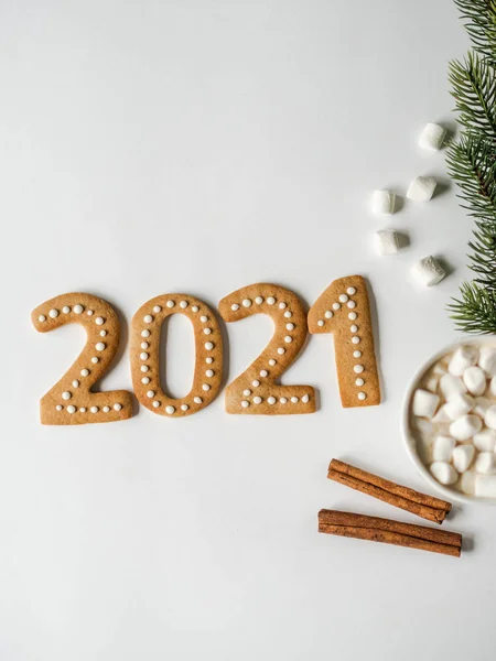 Gingerbread of the form of numbers. 2021 new year ginger cookies and mug cacao with marshmallows and New Year\'s attributes on white background.