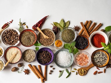 Çeşitli kuru baharatlar beyaz arka planda küçük kaselerde yatıyordu. Üst görünüm, alanı kopyala