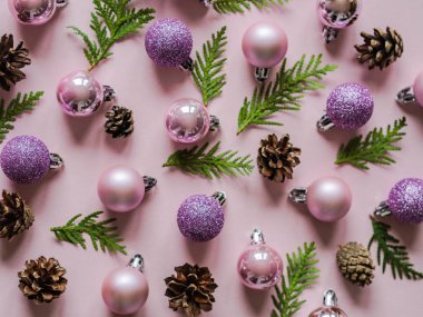 Pembe arka plan ve pembe farklı noel balosu, koniler ve Noel ağacı dalı düz uzanıyordu.