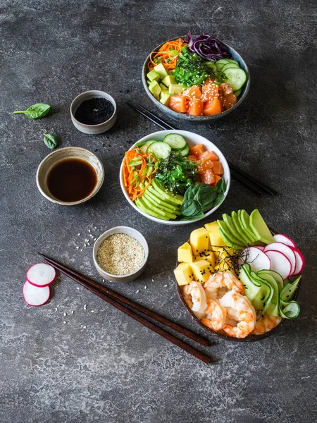 Asiento plano hawaiano salmón y camarones poke bowls con algas marinas, aguacate, mango, verduras crudas, semillas de sésamo. Vista superior, espacio de copia —  Fotos de Stock