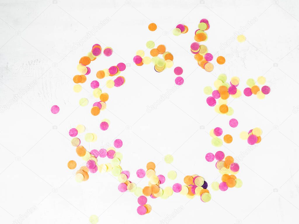 Colorful paper confetti scattered on a white background. Top view. Holiday decoration for vibrant life and fun. Copy space