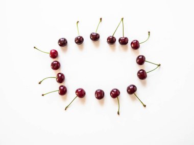 Beyaz arka planda büyük olgun kiraz çilekleri çerçevesi. Doğal yaz yemekleri geçmişi. Yaratıcı yemek yaz planı. en üstteki görünüm.