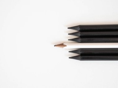 Beyaz kalem, beyaz arka planda siyah kalın kalemler ve uzay metinleriyle aynı kalabalığın önünde duruyor. Liderlik, benzersiz, konsept.