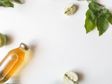 Cam şişede ev yapımı elma sirkesi. Fermente edilmiş elma suyu, taze elma ve beyaz arka planda yapraklar. Düz yatıyordu. Üst Manzara. Boşluğu kopyala