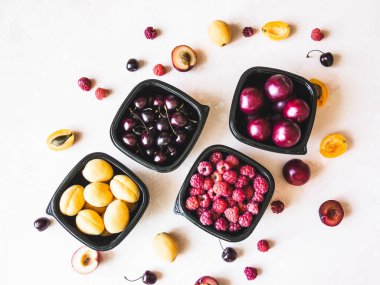 Taze böğürtlenler tepsilerde toplanır. Vitamin zengini meyveler kutularda paketlenir. Bir mağazada satılık çeşitli meyveler. Lezzetli meyveler.